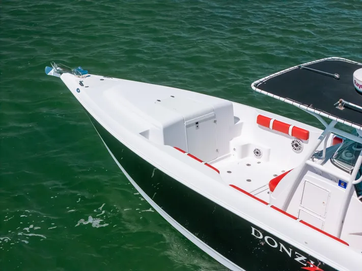  Yacht Photos Pics 2007 Donzi 38 ZF Cuddy boat on green water, showcasing sleek design and spacious deck.