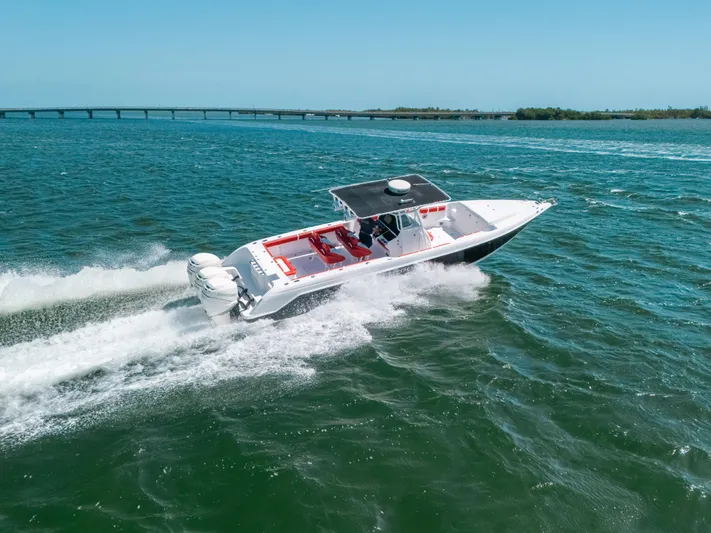  Yacht Photos Pics 2007 Donzi 38 ZF Cuddy speeding on open water, bridge in background.
