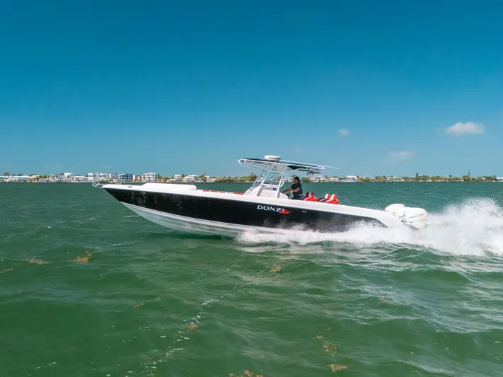  Yacht Photos Pics 2007 Donzi 38 ZF Cuddy boat cruising on open water under clear blue skies.