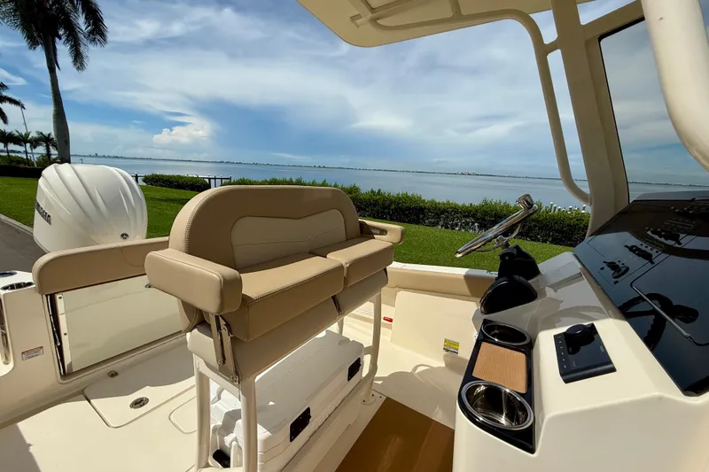  Yacht Photos Pics 2025 Scout 240 XSF boat interior with helm, seating, and scenic waterfront view.