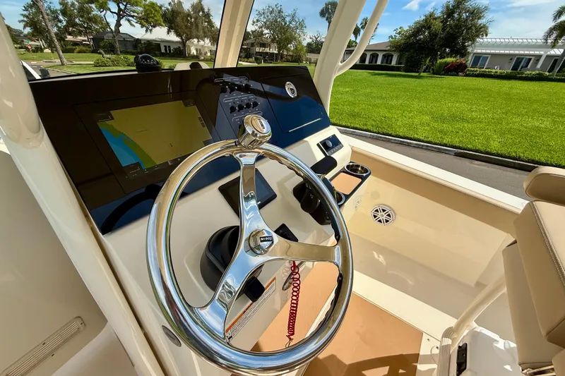  Yacht Photos Pics 2025 Scout 240 XSF boat dashboard with steering wheel and navigation display.