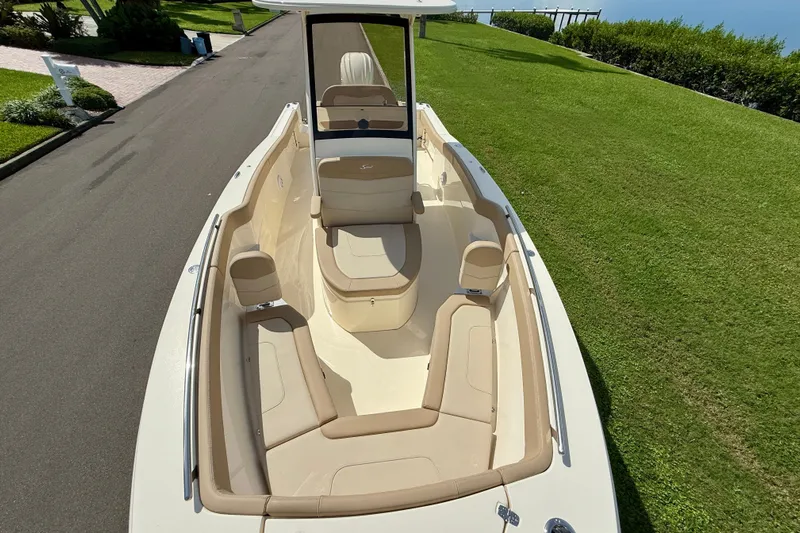  Yacht Photos Pics 2025 Scout 240 XSF boat with spacious seating, parked on a lush green lawn.
