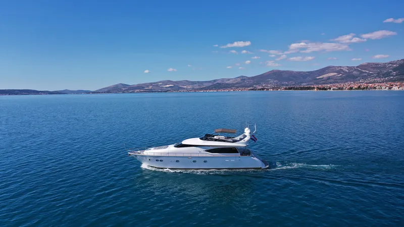 Hope I Yacht Photos Pics Maiora 20S 2008 yacht cruising on a serene blue sea with mountains in the background.