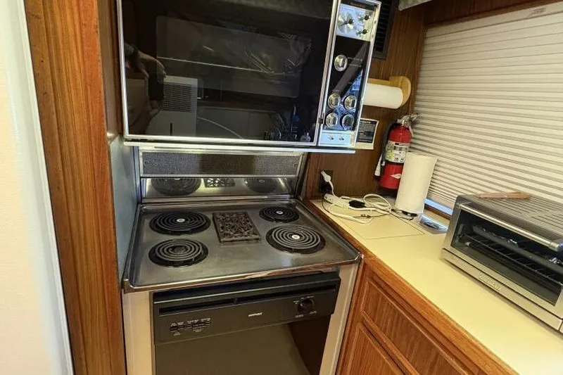 Keepem Flying Yacht Photos Pics 1985 Hatteras 60 enclosed bridge kitchen with stove, oven, and countertop appliances.