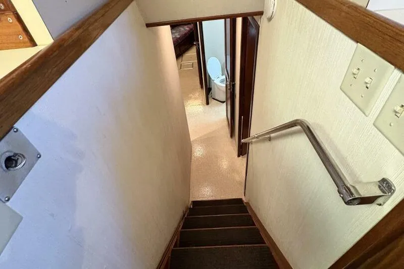 Keepem Flying Yacht Photos Pics Stairway leading to bathroom in 1985 Hatteras 60 enclosed bridge yacht interior.