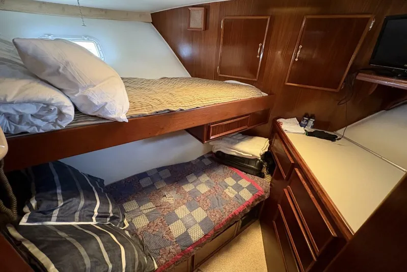 Keepem Flying Yacht Photos Pics Cozy cabin interior of 1985 Hatteras 60 enclosed bridge with bunk beds and wooden cabinetry.