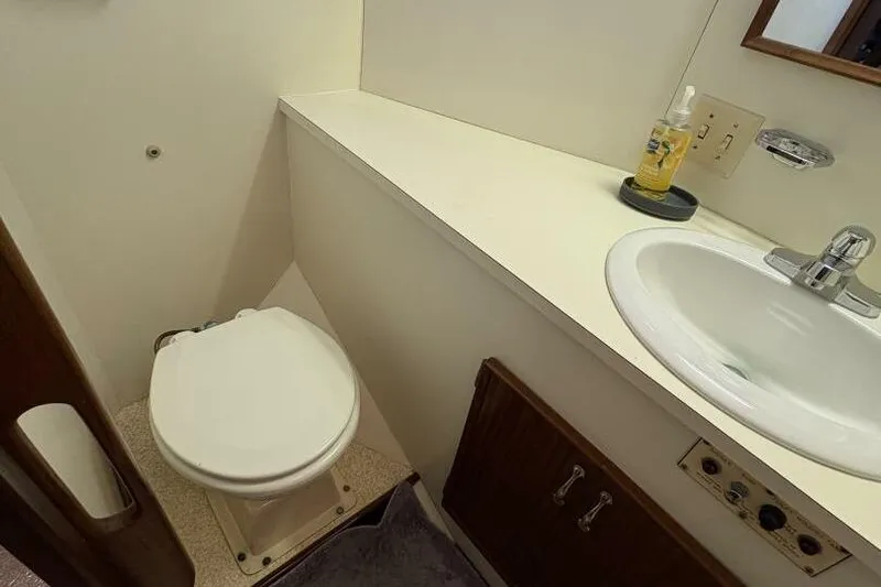 Keepem Flying Yacht Photos Pics Bathroom interior of 1985 Hatteras 60 enclosed bridge yacht, featuring sink and toilet.