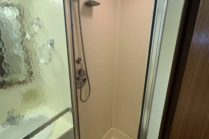 Keepem Flying Yacht Photos Pics Shower area in 1985 Hatteras 60 enclosed bridge yacht with glass door and modern fixtures.