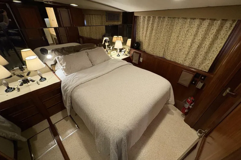 Keepem Flying Yacht Photos Pics Luxurious bedroom interior of 1985 Hatteras 60 enclosed bridge yacht with elegant decor.