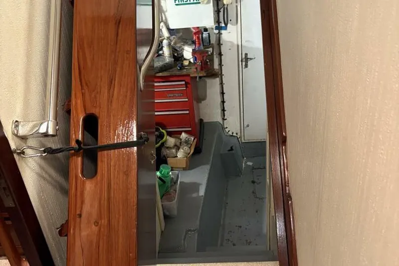 Keepem Flying Yacht Photos Pics Interior view of 1985 Hatteras 60 enclosed bridge with wooden door and tool storage.