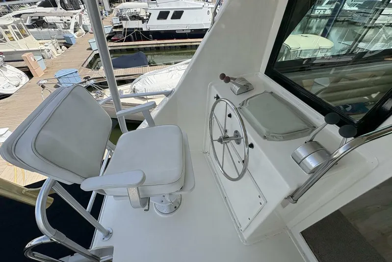Keepem Flying Yacht Photos Pics 1985 Hatteras 60 Enclosed Bridge helm with steering wheel and captain's chair.