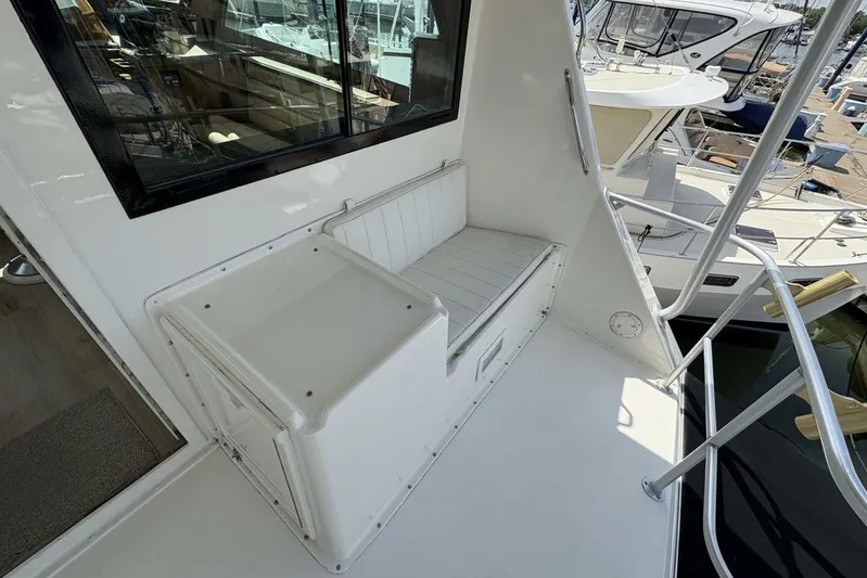 Keepem Flying Yacht Photos Pics 1985 Hatteras 60 Enclosed Bridge yacht with white seating and railing, docked at marina.