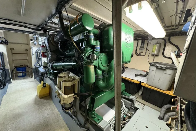 Keepem Flying Yacht Photos Pics Engine room of 1985 Hatteras 60 enclosed bridge yacht, featuring green machinery and storage bins.