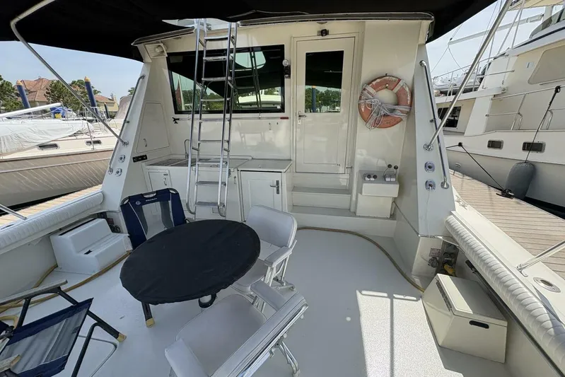 Keepem Flying Yacht Photos Pics 1985 Hatteras 60 Enclosed Bridge yacht deck with seating and ladder.