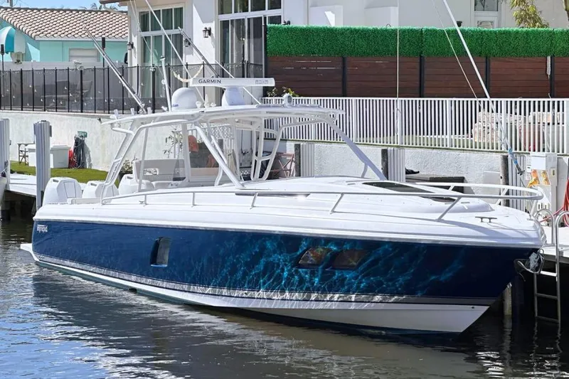  Yacht Photos Pics 2015 Intrepid 400 Cuddy boat docked, featuring sleek design and blue hull.