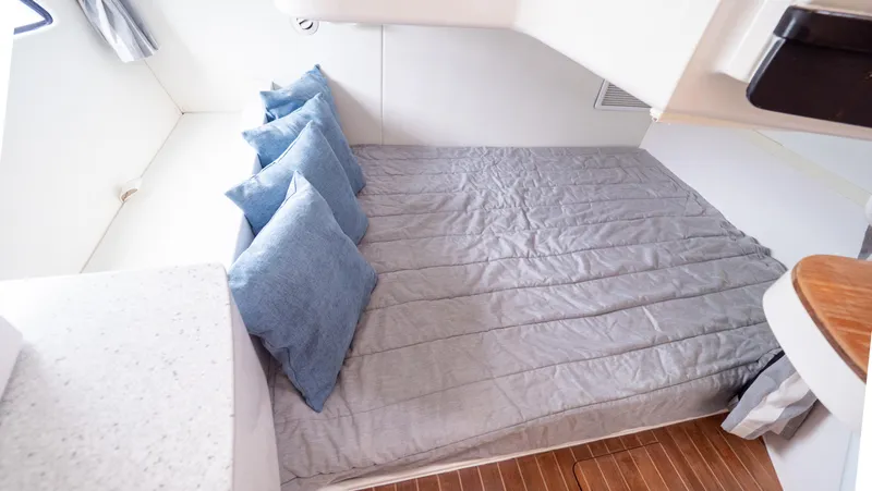  Yacht Photos Pics Cozy cabin interior of 2015 Intrepid 400 Cuddy with bed and blue pillows.