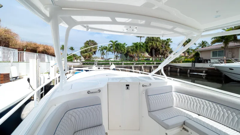  Yacht Photos Pics 2015 Intrepid 400 Cuddy boat interior with white seating, docked near palm trees.