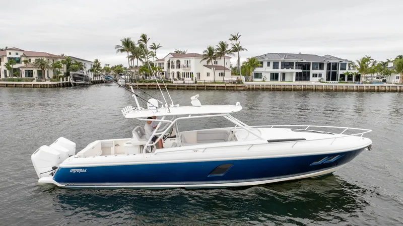  Yacht Photos Pics 2015 Intrepid 400 Cuddy boat on water near luxury waterfront homes.