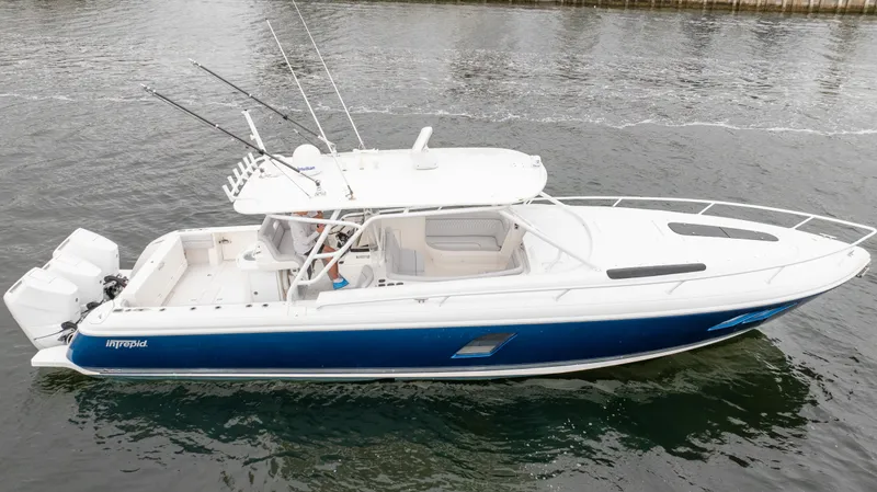  Yacht Photos Pics 2015 Intrepid 400 Cuddy boat with blue hull, docked on calm water.