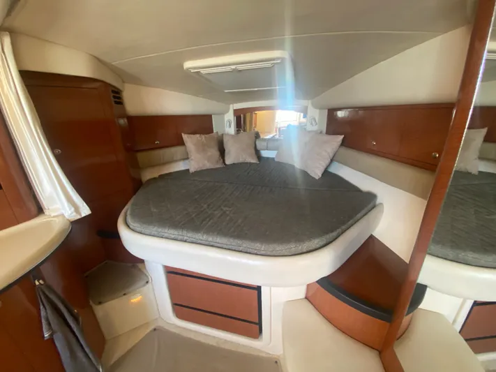 No Fly Zone Yacht Photos Pics Interior cabin of 2003 Sea Ray 340 Sundancer with cozy bed and wooden accents.