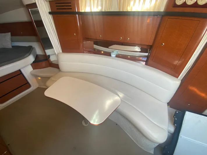 No Fly Zone Yacht Photos Pics 2003 Sea Ray 340 Sundancer interior with curved seating and wooden cabinetry.