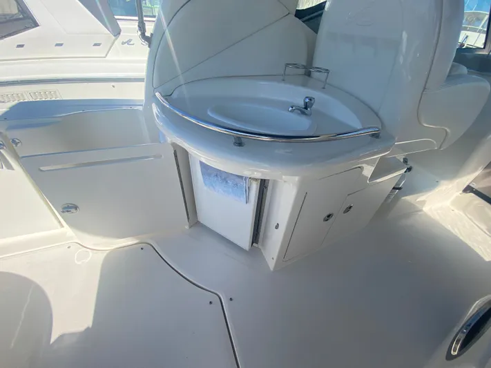 No Fly Zone Yacht Photos Pics 2003 Sea Ray 340 Sundancer cockpit sink and storage area, featuring sleek white design.