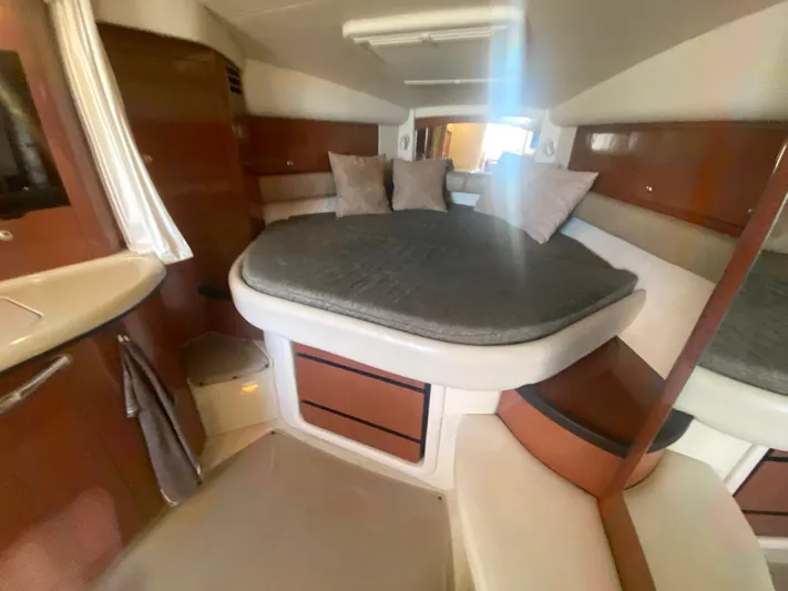 No Fly Zone Yacht Photos Pics Interior cabin of 2003 Sea Ray 340 Sundancer with cozy bed and wooden accents.