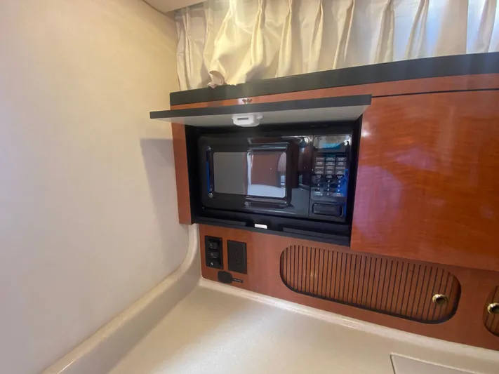 No Fly Zone Yacht Photos Pics 2003 Sea Ray 340 Sundancer interior with microwave and wooden cabinetry.