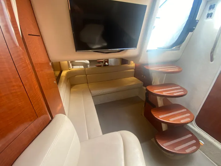 No Fly Zone Yacht Photos Pics Luxurious interior of 2003 Sea Ray 340 Sundancer with plush seating and wooden steps.