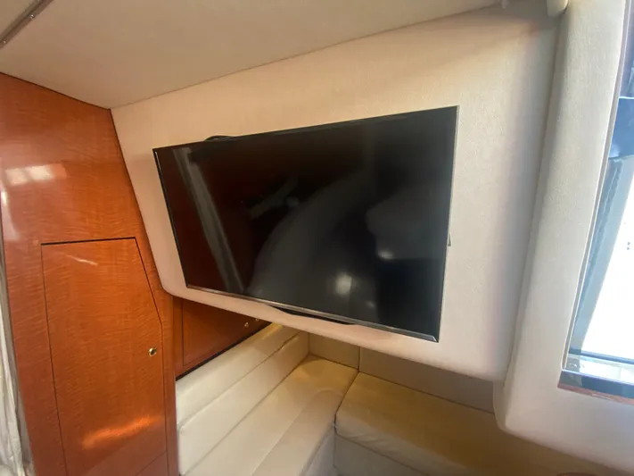 No Fly Zone Yacht Photos Pics Interior of 2003 Sea Ray 340 Sundancer with mounted TV and wooden cabinetry.