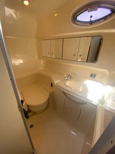 No Fly Zone Yacht Photos Pics 2003 Sea Ray 340 Sundancer bathroom with sink, toilet, and storage cabinets.
