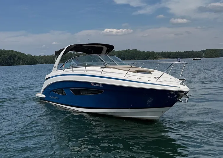 Wine-n-down Yacht Photos Pics 2014 Regal 32 Express boat on a calm lake under a partly cloudy sky.