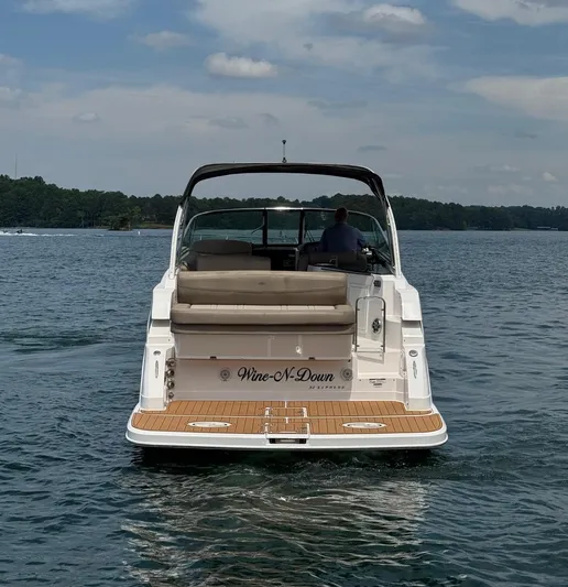 Wine-n-down Yacht Photos Pics 2014 Regal 32 Express boat on water, rear view, with "Wine-N-Down" name.