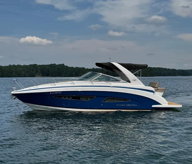 Wine-n-down Yacht Photos Pics 2014 Regal 32 Express boat on a calm lake under a partly cloudy sky.