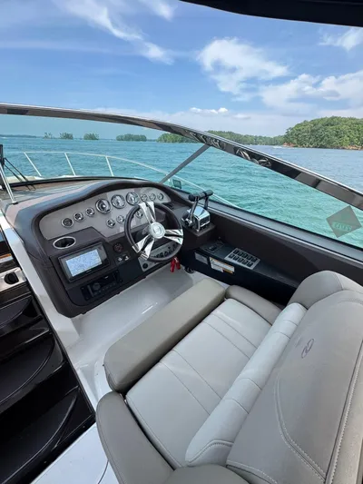 Wine-n-down Yacht Photos Pics 2014 Regal 32 Express boat cockpit with steering wheel, dashboard, and scenic water view.