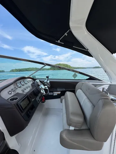 Wine-n-down Yacht Photos Pics 2014 Regal 32 Express boat interior with steering wheel and dashboard, overlooking a scenic lake.