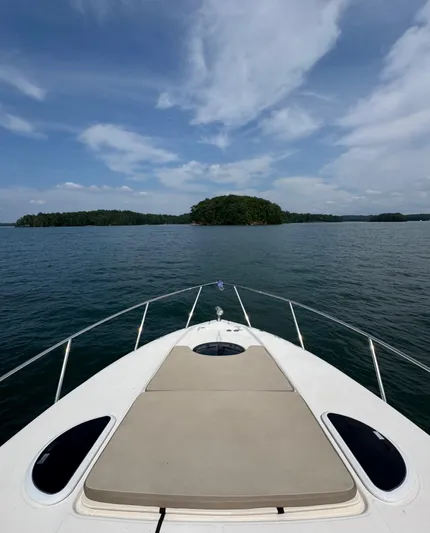 Wine-n-down Yacht Photos Pics 2014 Regal 32 Express boat cruising on a serene lake under a blue sky.