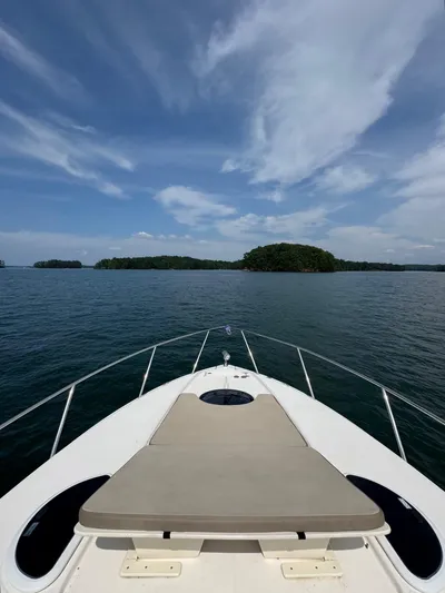 Wine-n-down Yacht Photos Pics Bow view of 2014 Regal 32 Express yacht on a serene lake under a blue sky.