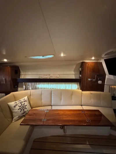 Wine-n-down Yacht Photos Pics Interior of 2014 Regal 32 Express yacht with cozy seating and wooden table.