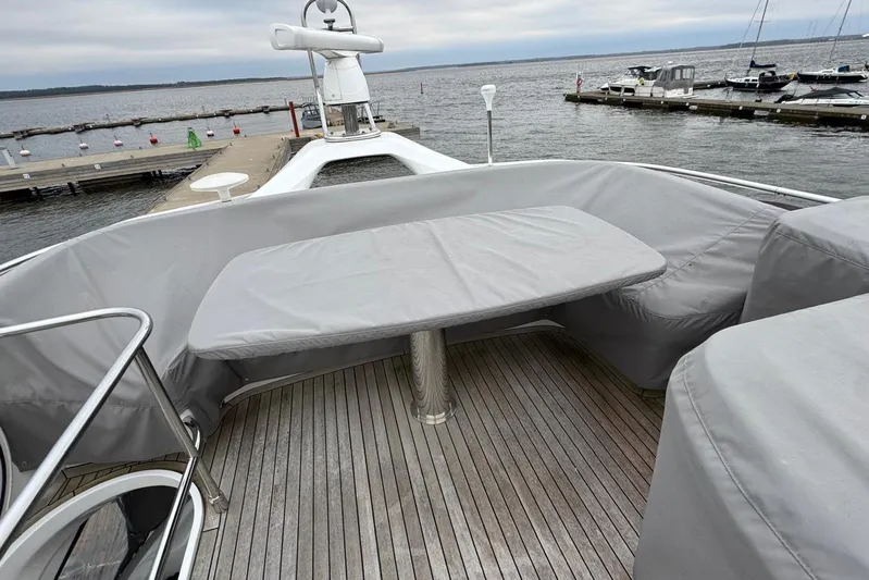  Yacht Photos Pics Princess F45 yacht deck with covered seating and table, docked by the water.