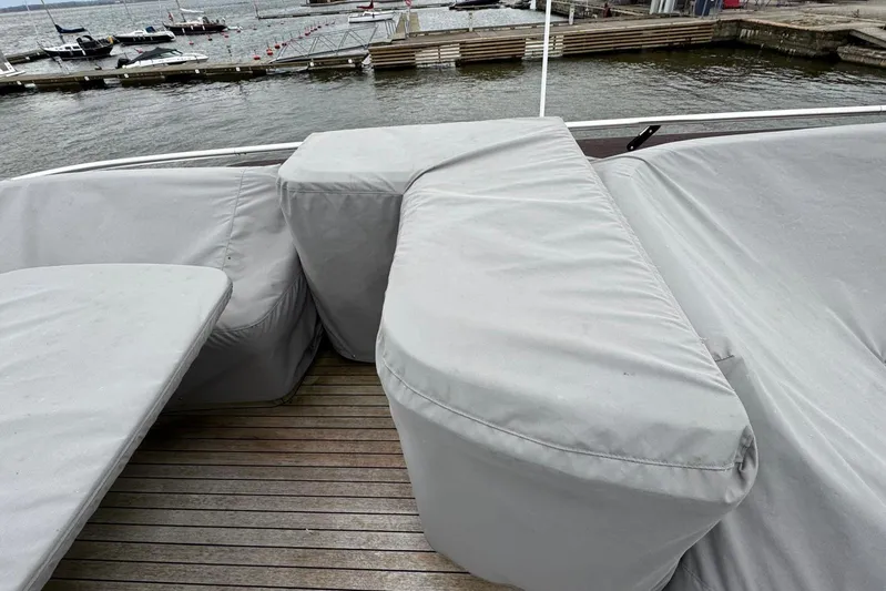  Yacht Photos Pics Covered seating area on a 2021 Princess F45 yacht, docked by the water.