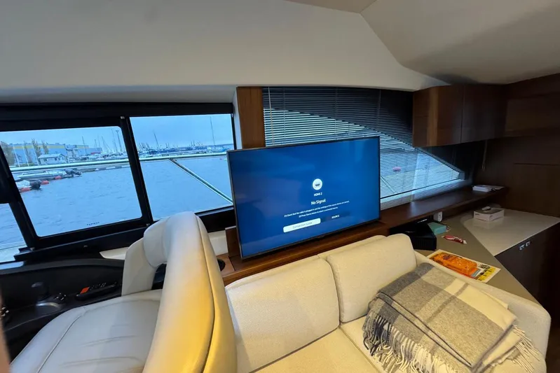  Yacht Photos Pics Interior of 2021 Princess F45 yacht with sofa, TV, and marina view.