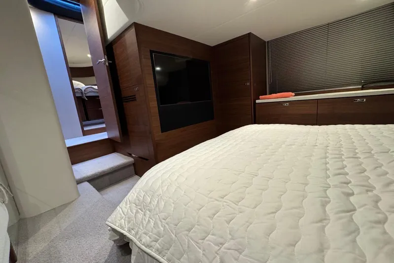  Yacht Photos Pics Luxurious bedroom interior of 2021 Princess F45 yacht with modern wood finishes.