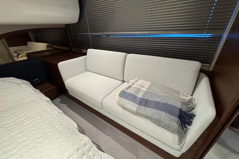  Yacht Photos Pics Luxurious interior of 2021 Princess F45 yacht with cozy sofa and blanket.