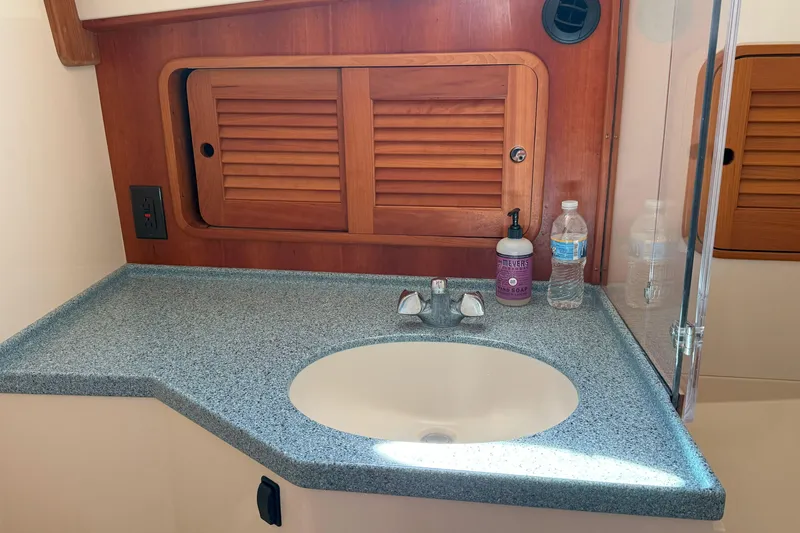 Madeline Kathleen Yacht Photos Pics Hinckley Talaria 40 (2003) bathroom sink with wooden cabinet and countertop accessories.