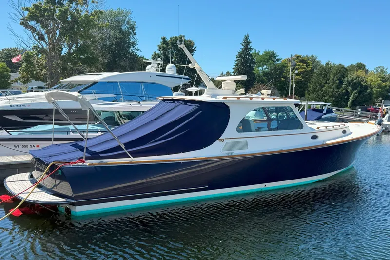 Madeline Kathleen Yacht Photos Pics 2003 Hinckley Talaria 40 yacht docked, featuring a sleek blue hull and covered deck.