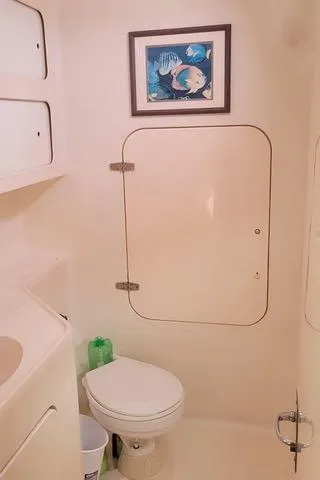 Hazey Daze Yacht Photos Pics Compact bathroom in 2001 Voyage Maxim boat with framed ocean artwork.