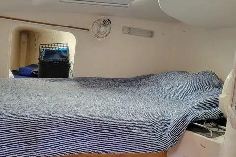 Hazey Daze Yacht Photos Pics Cozy cabin interior of 2001 Voyage Maxim with striped bedding and storage space.