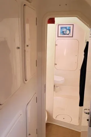 Hazey Daze Yacht Photos Pics Compact bathroom interior of 2001 Voyage Maxim yacht with white fixtures and wall art.