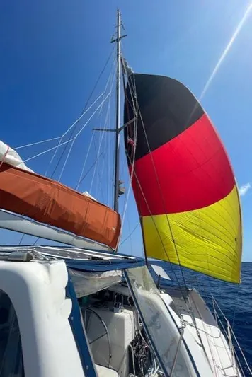 Hazey Daze Yacht Photos Pics Sailing yacht Voyage Maxim 2001 with colorful sails against a clear blue sky.